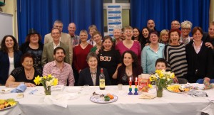Group of around 20 people at a Seder table